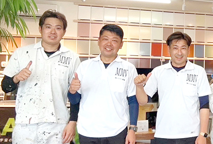 写真：笑顔で肩を組む職人たち