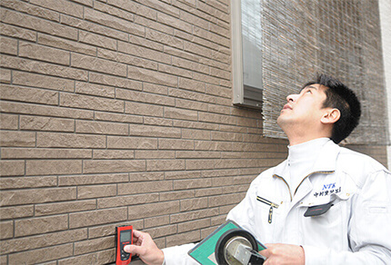 写真：外壁の診断を行なっている職人
